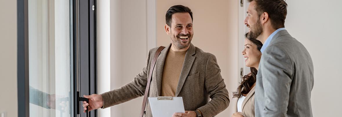 Male real estate agent showing a couple a house