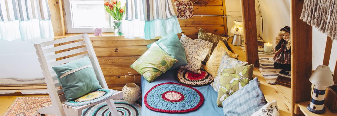 Maximalist maximalist home concept. Holiday home cabin bedroom with natural wooden board walls and ceiling and lot of different color details.