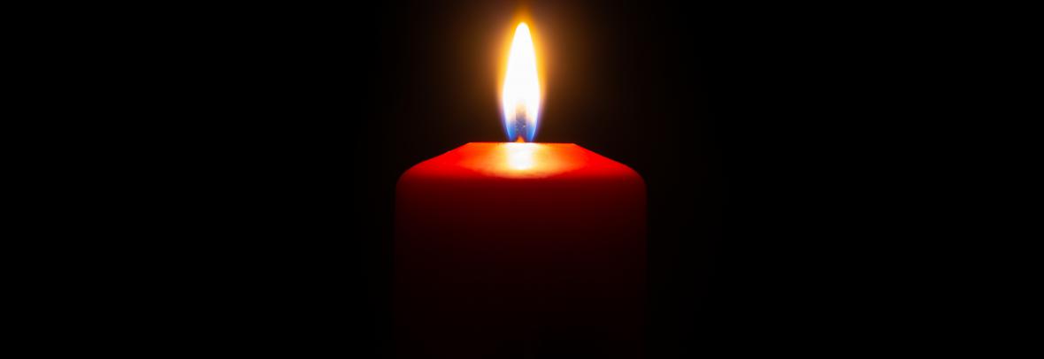 small red candle lit with a black background