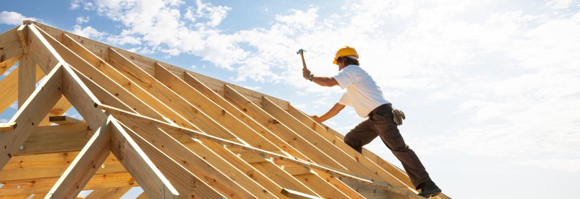 construction worker hammering on a roof