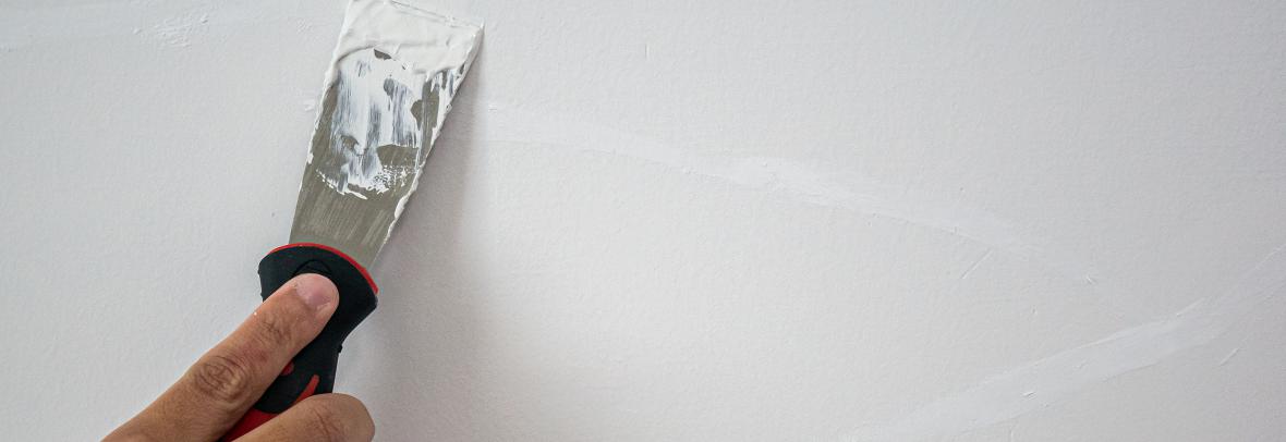 Plasterer hand repair crack white wall