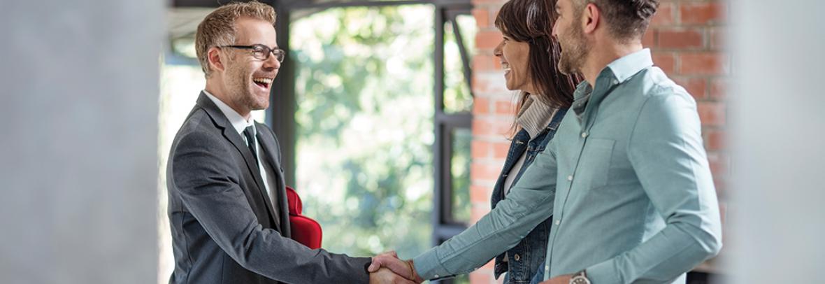 Real Estate agent shaking hands with a couple