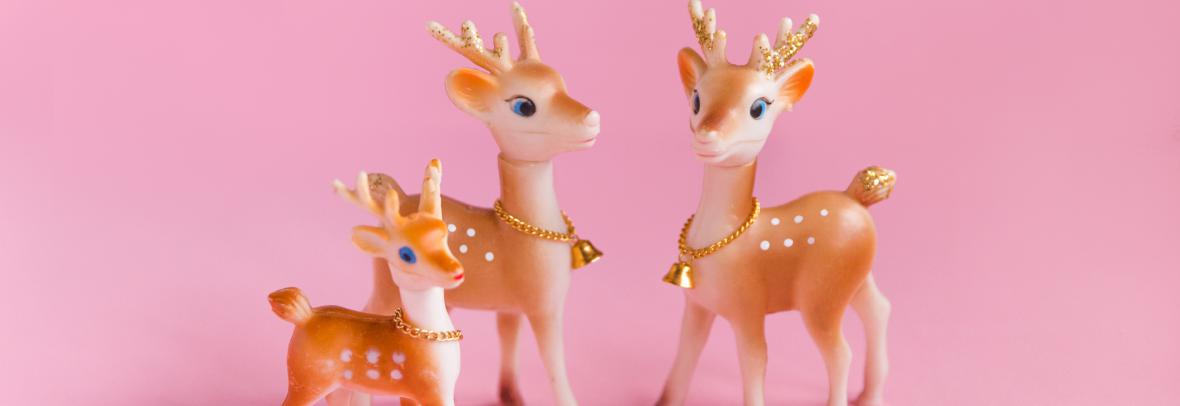 Pink Christmas Background with Vintage Reindeer Family - stock photo Vintage Christmas background, conceptual family, no people. Plastic reindeer family Christmas decorations on pink background. Conceptual image for mother and father, family with one child, and family themes. Copy space.