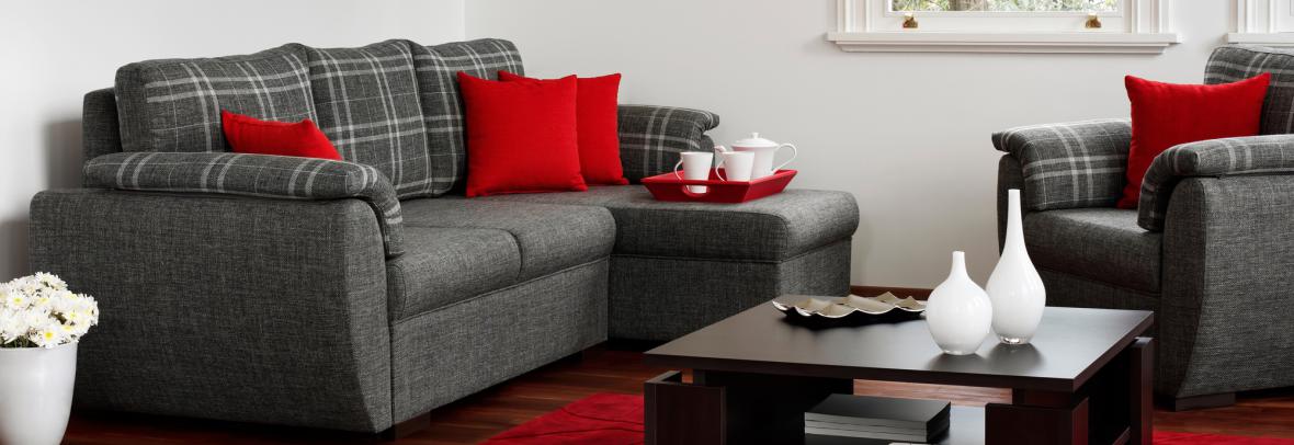 a touch of red in a living room. red pillows on a gray couch and chair and a red carpet