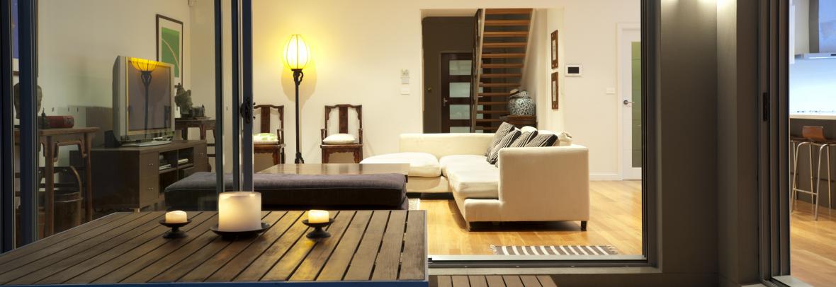Indoor-outdoor living space with couch in living room and table on patio