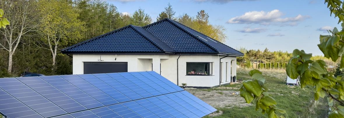 New house under construction with solar panels in the yard. Eco power source green energy concept.