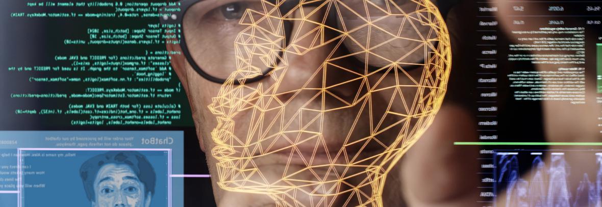 Close up stock image. Looking through a touch screen display to a man’s face. He’s studying imagery depicting AI (artificial intelligence) avatars, chatbots & associated coding.