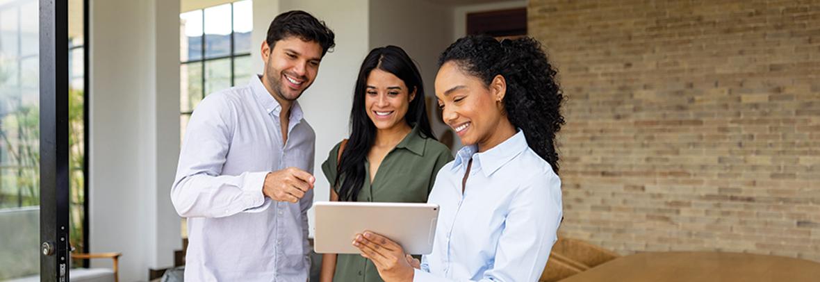 Photo of real estate agent with clients looking at buyer agreement