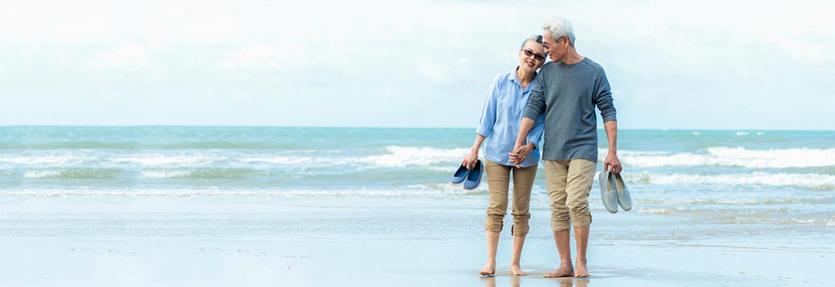 photo of a retired asian couple on the beach