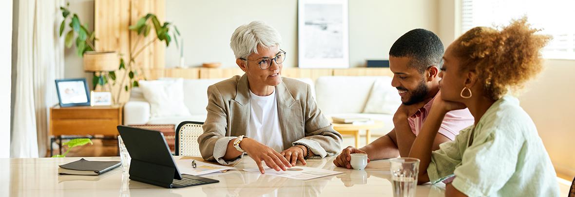 Photo of real estate agent talking to clients at dining room table