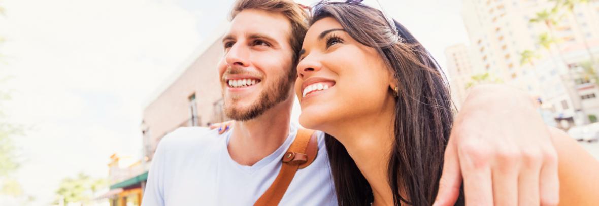 Smiling couple outdoors looking up