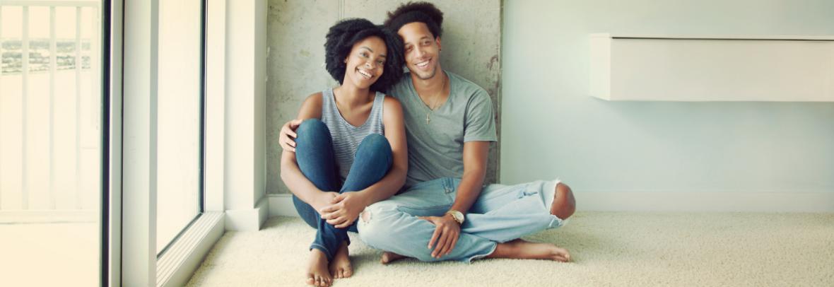 Happy couple sitting on floor of new home