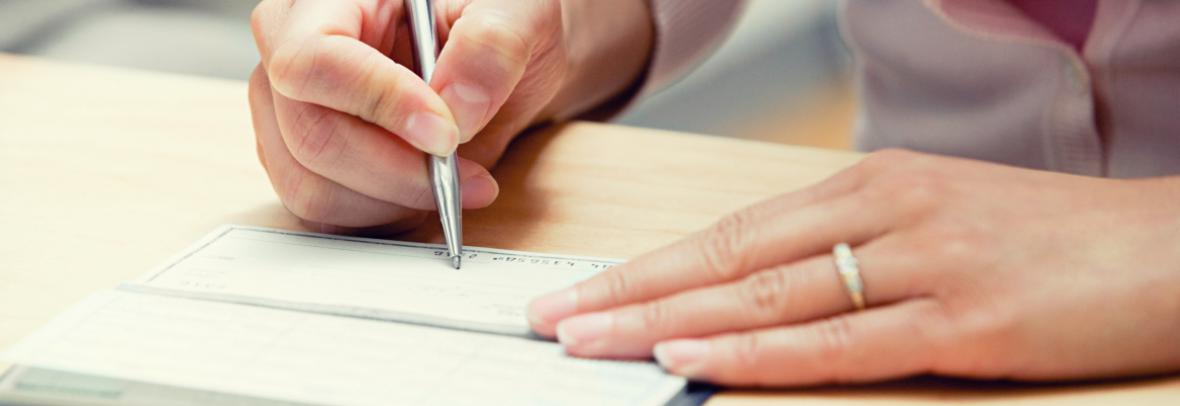 woman's hands writing a check