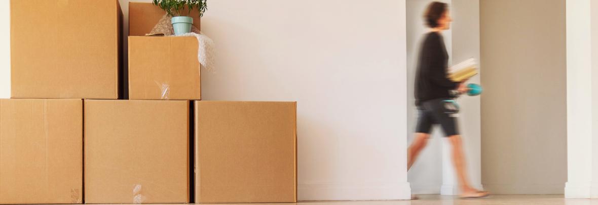 woman walking past doorway and moving boxes 