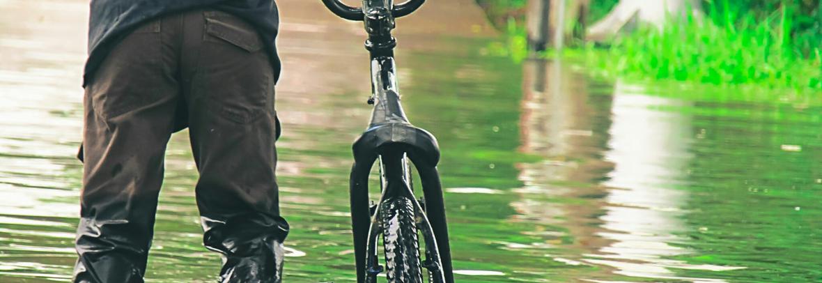 Man with bike in floodwater