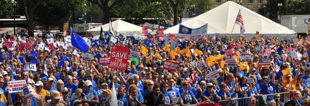 people holding signs and flags at real estate rally in washington