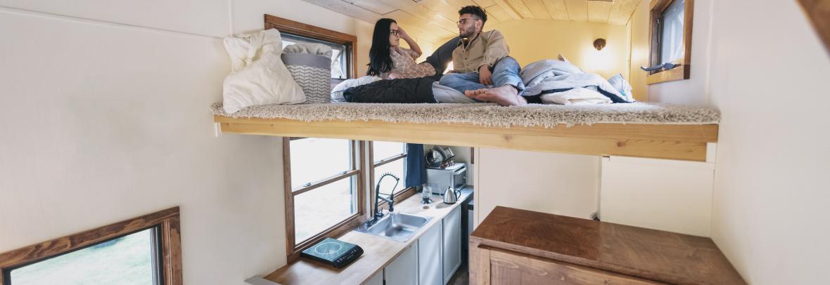 Couple in loft bed inside a tiny home