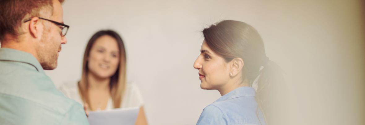 couple sitting with woman with paperwork