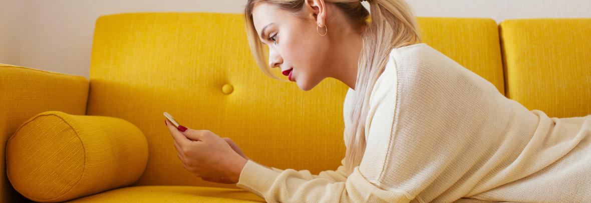 woman on sofa looking at phone