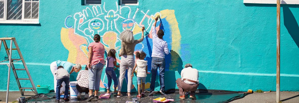 People painting a mural on a building