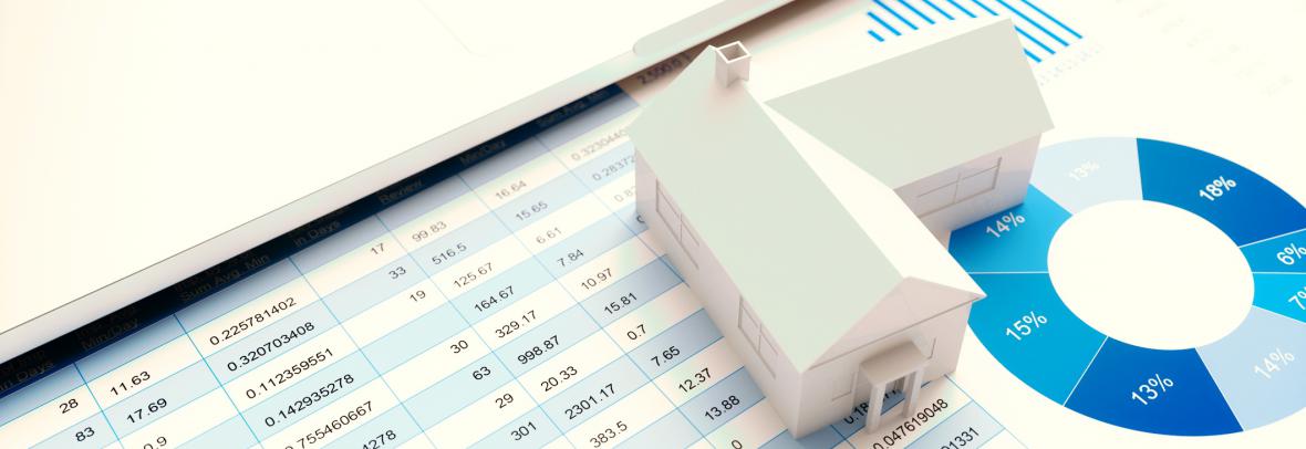 miniature house sitting on top of market statistics