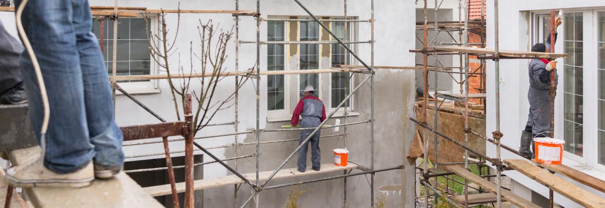 Workers on scaffolding on exterior of a building