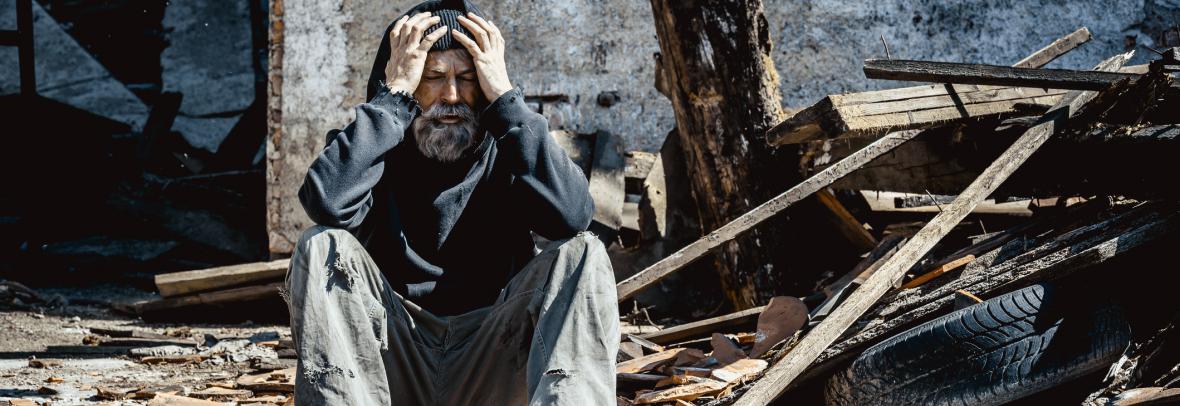 distraught man sitting in rubble