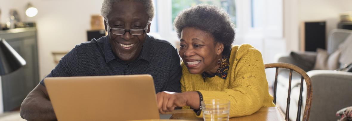 older couple looking at computer and smiling