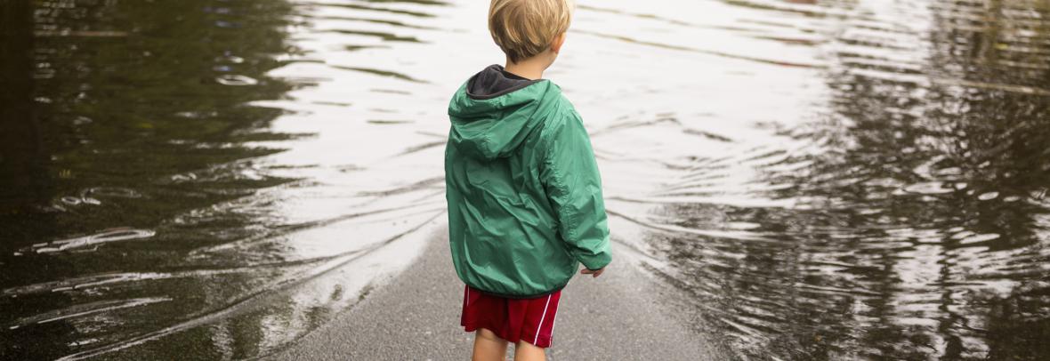 little boy looking at floodwaters