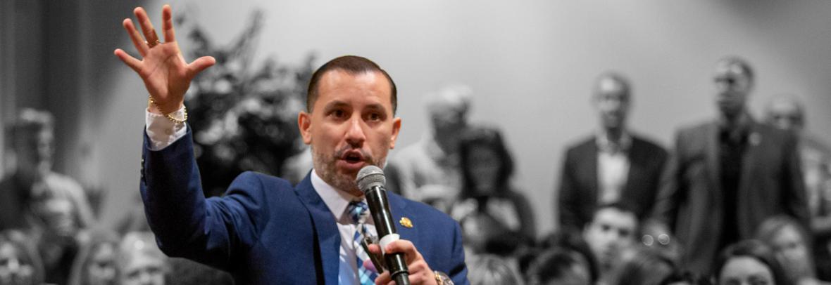 Man speaking into microphone to crowd