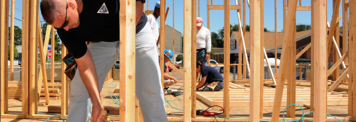 Man pounding nails building an affordable home