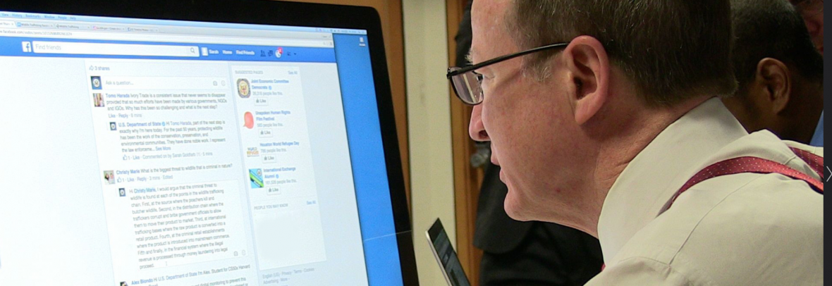 Man at computer looking at Facebook