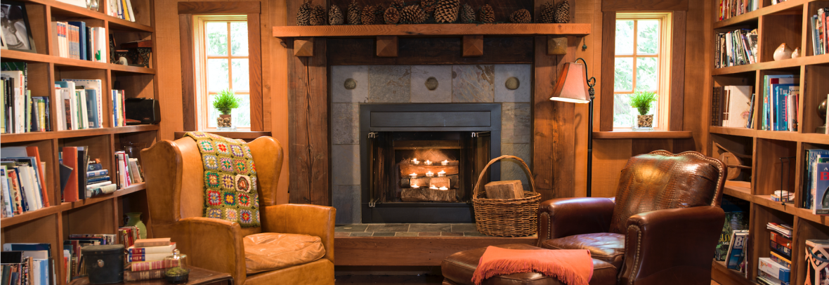 Fireplace in a wooden study with two leather chairs