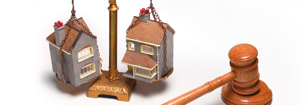 Scales weigh two homes with gavel along the side