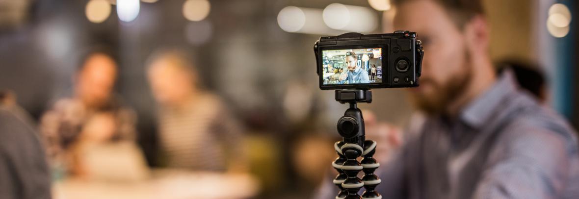 Man holding camera on tripod