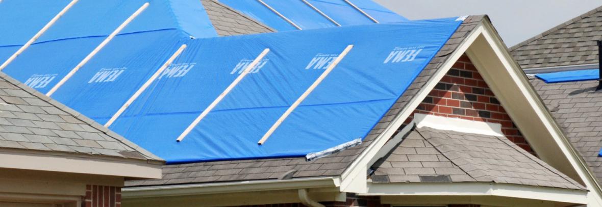 Blue tarps cover a roof