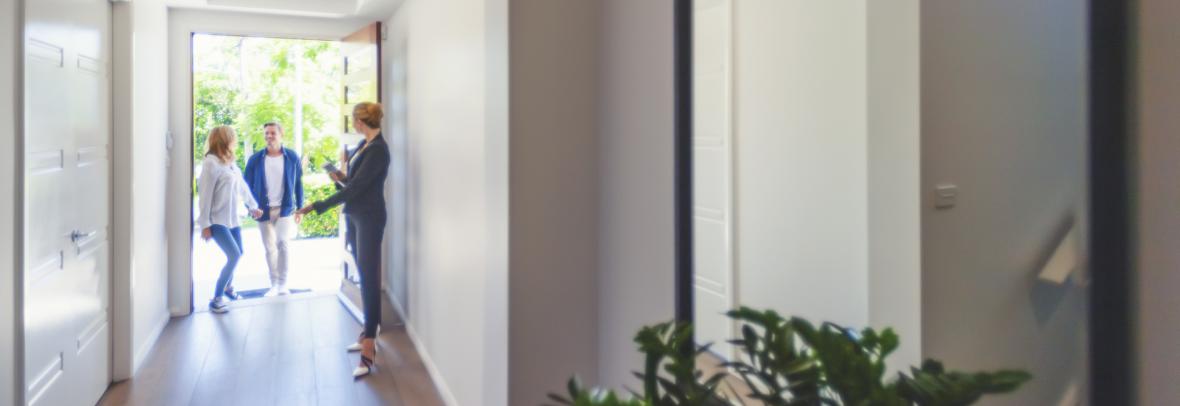 Real estate agent showing a young couple a new house.