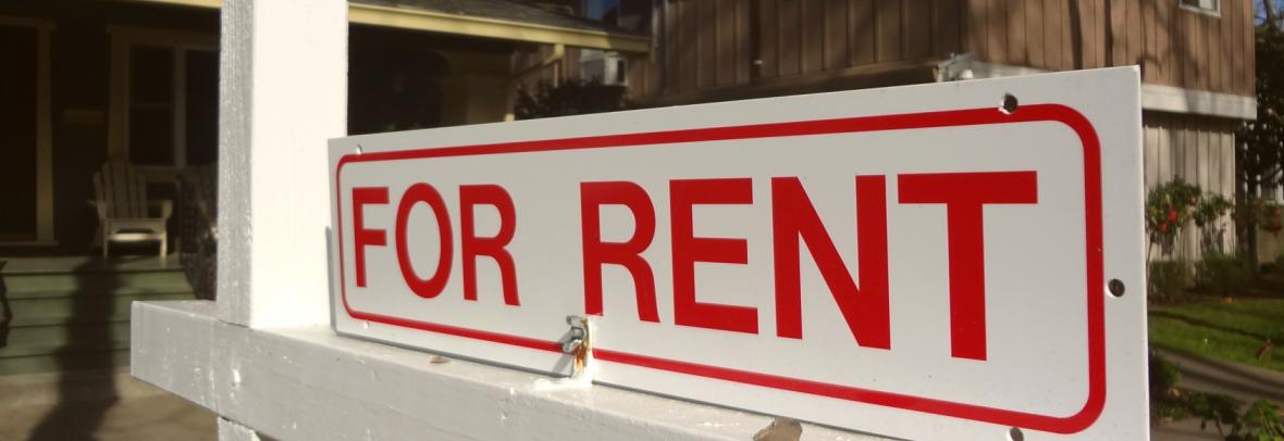 Single-family home with for-rent sign out front