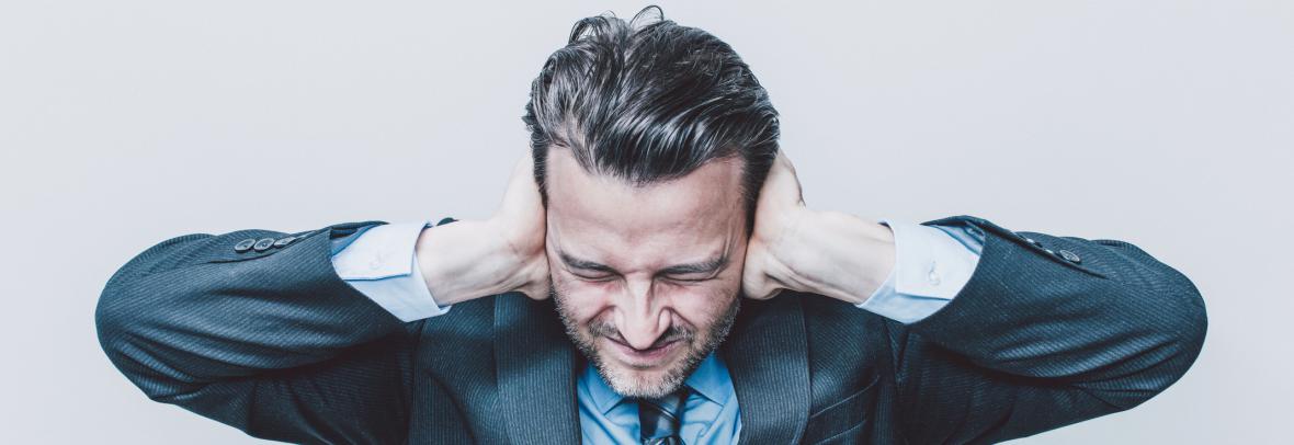 Man holding ears due to noise