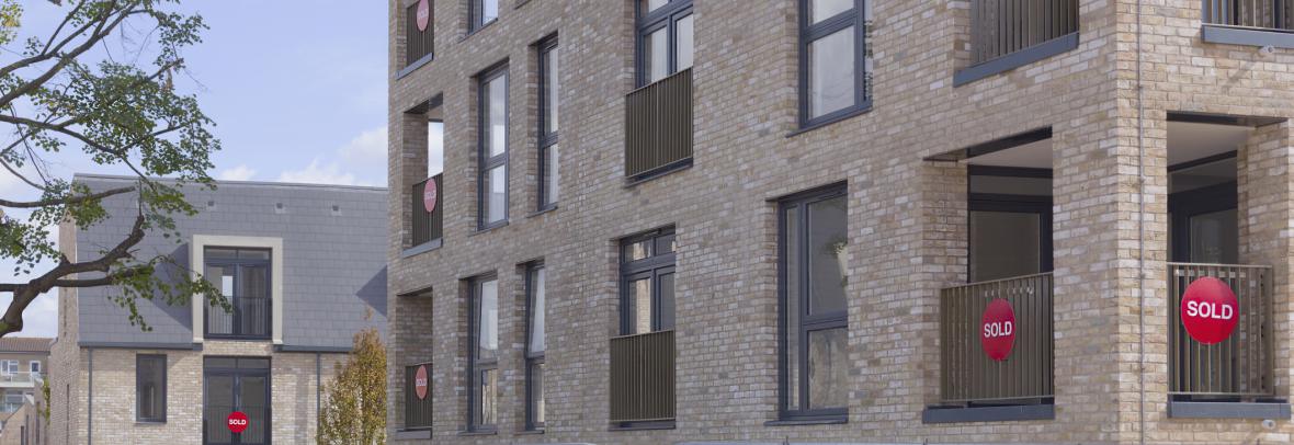 Condo building with sold signs on two balconies
