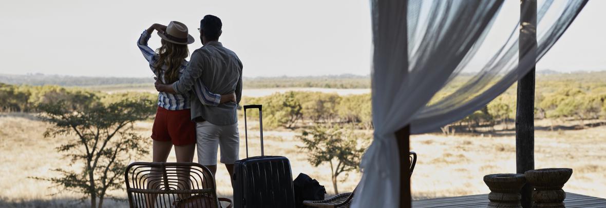 Couple under outdoor canopy with suitcases