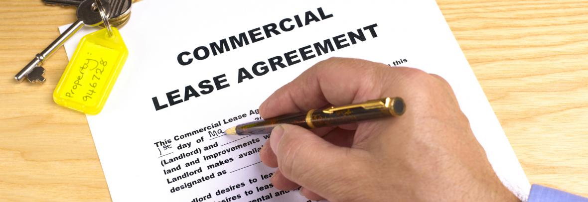 Man's hand signing lease agreement