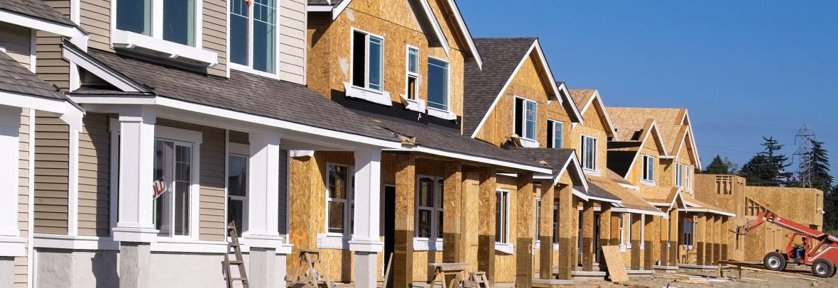Perspective photo of a row of similar style houses during various phases of construction.