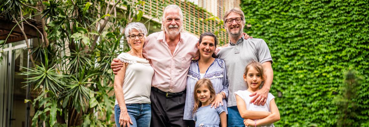 Five people from three generations tand in front of a house