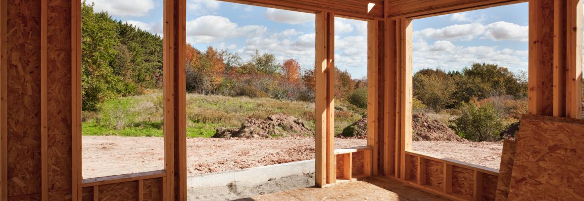 Partially constructed room with large windows and doors facing greenspace