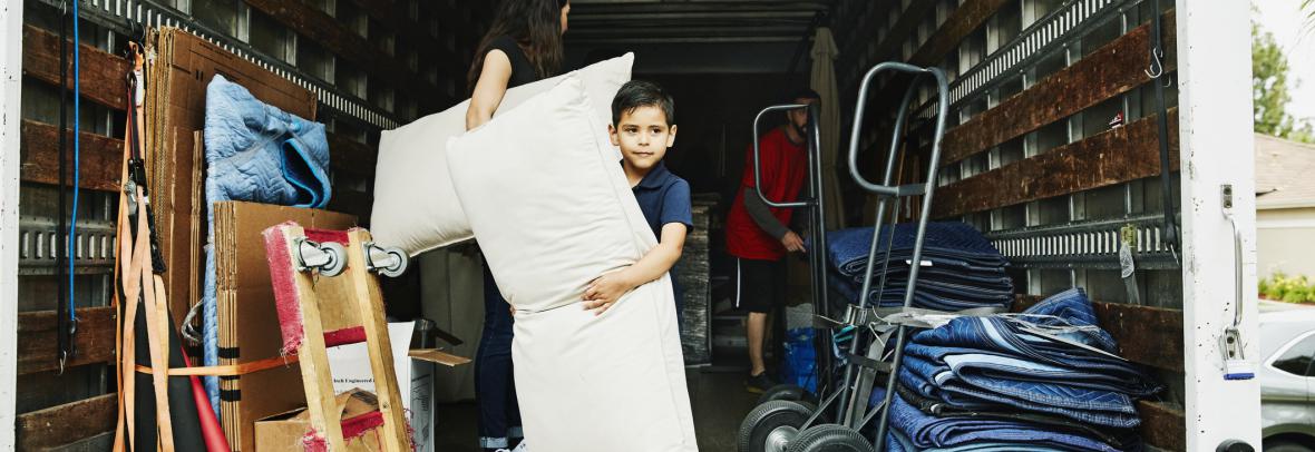 Ten-year old in the back of a moving van helping to unload