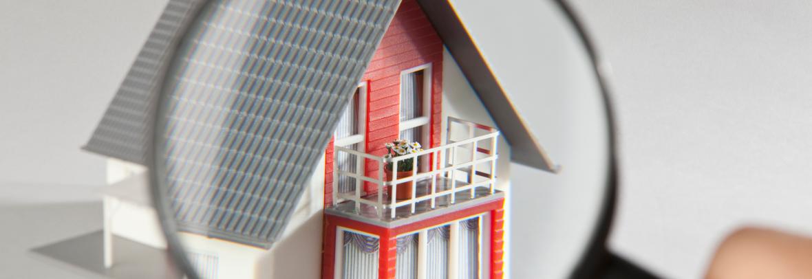 A model house viewed through a magnifying glass - stock photo