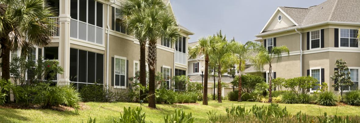 Several condo buildings with screened porches abut a lake