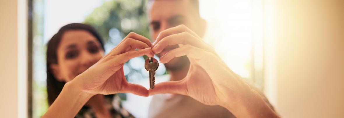 Portrait of a young couple holding the keys to their new home