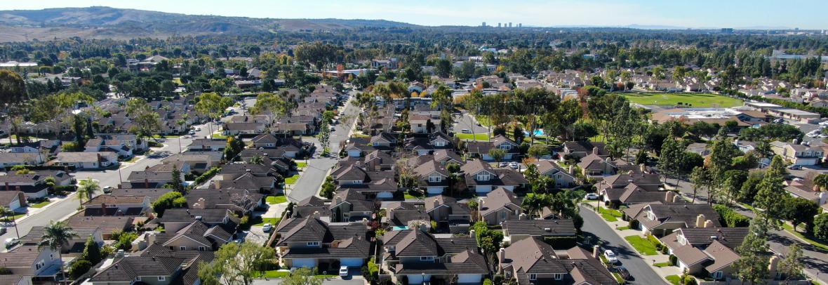 Aerial view of residential suburban packed homes neighborhood during blue sky day in Irvine, Orange County, USA